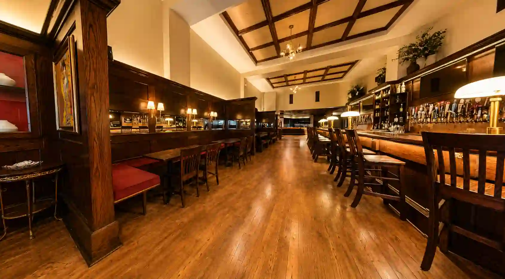 The main bar with craft beer tap wall, barstools and coffered wood ceiling