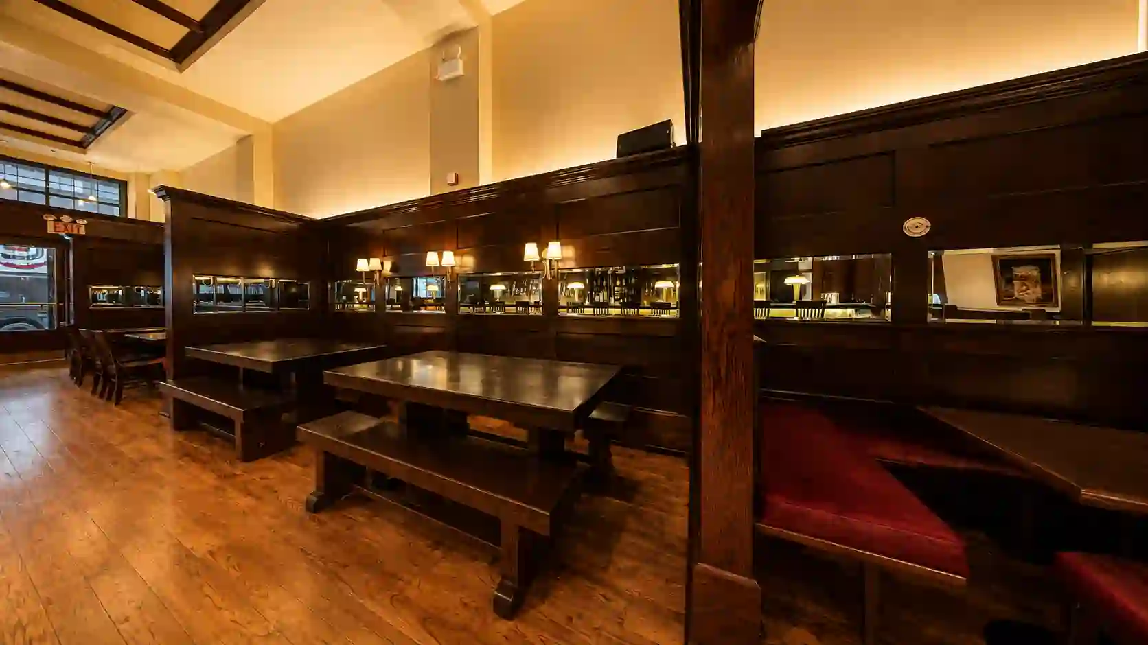 Dark wood booth alcoves with communal tables and benches